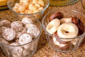 four plastic containers of different types of donuts on a counter at Hotel Laghetto Viale in Gramado