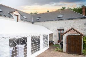 une serre blanche devant une maison dans l'établissement Espace Des Fées, à Saint-Laurent-Nouan