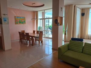 uma sala de estar com uma mesa e cadeiras e um sofá em Guest Rooms DEVA em Burgas