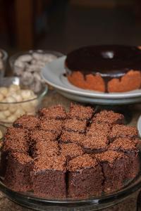 a table topped with chocolate cakes and plates ofcakes at Hotel Laghetto Viale in Gramado