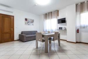 ein Wohnzimmer mit einem Tisch, Stühlen und einem Sofa in der Unterkunft Ca' Ida - Affitti Temporanei in Turin