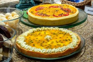 two cakes are sitting on plates on a table at Hotel Laghetto Viale in Gramado
