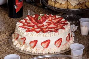 a cake with strawberries on top of it on a table at Hotel Laghetto Viale in Gramado
