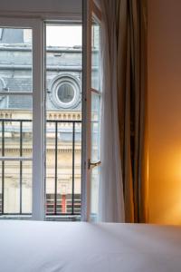 a bedroom with a window with a view of a building at Hôtel De Fleurie in Paris