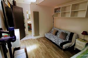 una sala de estar con un sofá con estampado de cebra en una habitación en Petit studio pour 4 personnes avec coin jardin, en Le Blanc-Mesnil