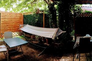 una hamaca en un patio junto a una valla en Petit studio pour 4 personnes avec coin jardin, en Le Blanc-Mesnil