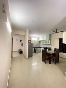 a large living room with a table and a kitchen at Bigson Service Apartments, Kondapur in Hyderabad
