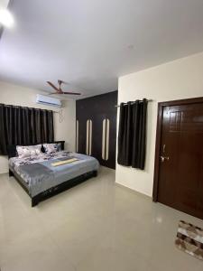 a bedroom with a bed and black cabinets and a door at Bigson Service Apartments, Kondapur in Hyderabad