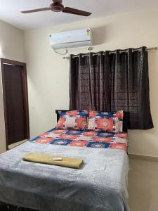 a bedroom with a bed with a ceiling fan at Bigson Service Apartments, Kondapur in Hyderabad