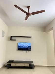 a ceiling fan in a living room with a flat screen tv at Bigson Service Apartments, Kondapur in Hyderabad