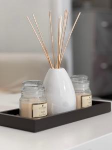 a tray with three jars and a vase with sticks at Studio proche Stade de France in Saint-Denis