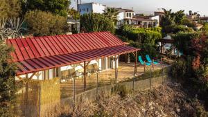 a house with a red roof and a fence at Sunset Retreat Cyprus in Pendakomo