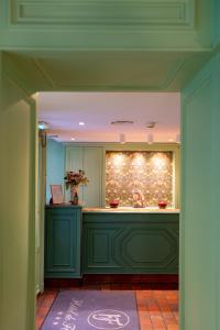 a kitchen with green cabinets and a counter top at Hôtel De Fleurie in Paris