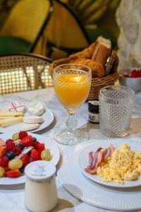 une table avec des plaques alimentaires et un verre de jus d'orange dans l'établissement Hôtel De Fleurie, à Paris