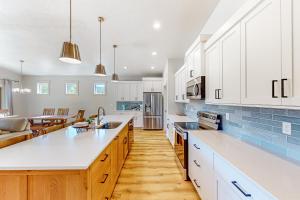 una cocina con armarios blancos y una gran isla de cocina en McCall's Mighty Marvel, en McCall