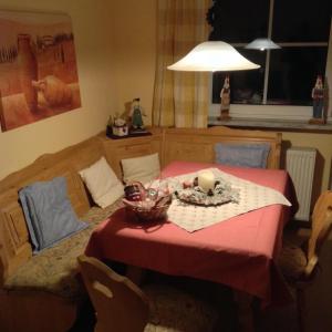 una mesa con un mantel rojo y una vela en ella en Appartement Haus Anja, en Bad Füssing