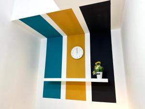 a colorful wall with a clock on a shelf at Charming Partition Room in Barsha Heights Near ICM in Dubai
