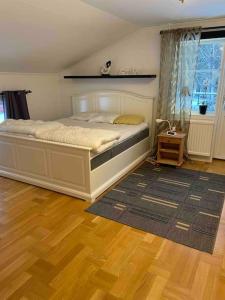 ein Schlafzimmer mit einem großen Bett und Holzboden in der Unterkunft Lantligt boende in Luleå