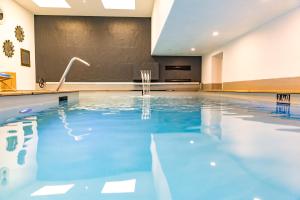 a swimming pool with blue water in a building at Baie des Anges in Landéda