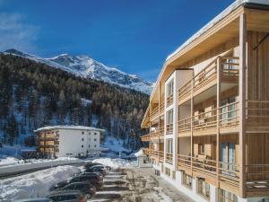 a large building with cars parked in a parking lot at Hotel Gertraud in Solda