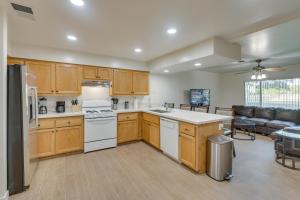 cocina con armarios de madera y sala de estar. en Convenient Bakersfield Townhome with Patio!, en Bakersfield