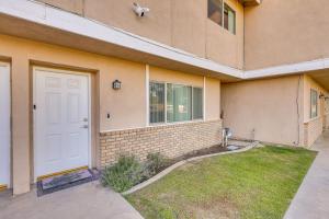 una casa con una puerta blanca y un patio de césped en Convenient Bakersfield Townhome with Patio!, en Bakersfield