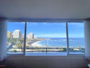 a window with a view of the beach and ocean at Apartamento en primera línea de playa in Puerto de la Cruz