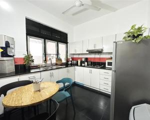 a kitchen with a table and a refrigerator at Aadaraya Colombo 7 in Colombo