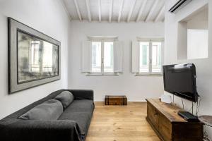 a living room with a couch and a flat screen tv at UNYCA - Residenza San Lorenzo in Florence