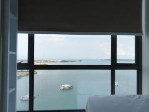 a view of the water from a bedroom window at Peaceful Sea view Cozy APT at Batam Center - By MESA in Batam Center