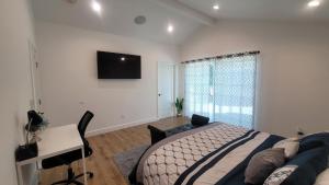 Dormitorio con cama, escritorio y TV en Gated private house with own parking Sherman Oaks en Los Ángeles