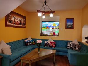 a living room with a blue couch and a table at Kitu Hotel in Quito