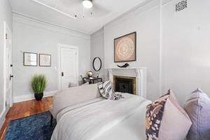 a white bedroom with a bed and a fireplace at Newly Renovated 3BR Oasis Walk to Columbia Uni in New York