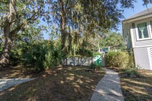 a house with a tree and a sidewalk at Edisto Hidden Oasis in Edisto Island