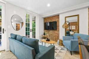 a living room with blue chairs and a tv at Newly Renovated 2BR w Rare Private Backyard and BBQ in New York