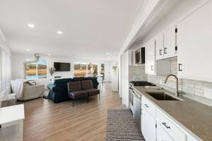 uma cozinha e sala de estar com um sofá e uma mesa em Waterfront Newly Renovated w Amazing Views em Oak Bluffs