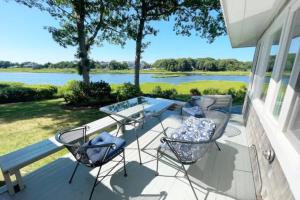um pátio com uma mesa e cadeiras e vista para um lago em Waterfront Newly Renovated w Amazing Views em Oak Bluffs
