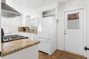 cocina con electrodomésticos blancos y nevera blanca en Cozy, home with hottub and patio, en San Diego