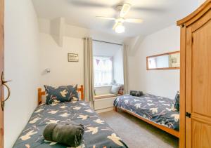 1 Schlafzimmer mit 2 Betten und einem Fenster in der Unterkunft Drum Cottage in Appledore