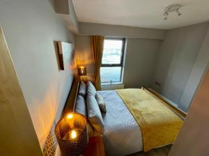 um pequeno quarto com uma cama e uma janela em Corinthian Quay Apartment em Edimburgo