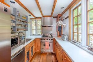 cocina con armarios de madera y fogones en Historic Estate - 5 min to Mohawk Mt Ski Resort 
