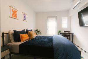 a bedroom with a bed with orange and blue pillows at 2Beds Apt walking distance to major hospitals - heart of Morris Park - Bronx 30 days plus in Morris Park