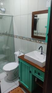 a bathroom with a toilet and a sink and a mirror at Paraíso tropical in Balneário Gaivotas