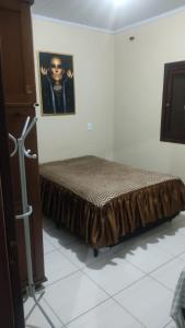 un letto in una camera con una foto sul muro di Paraíso tropical a Balneário Gaivotas
