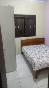 1 dormitorio con 1 cama con edredón de flores en Paraíso tropical en Balneário Gaivotas
