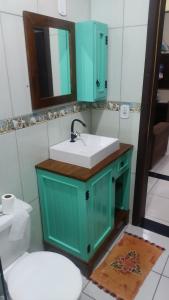 a bathroom with a sink and a mirror and a toilet at Paraíso tropical in Balneário Gaivotas