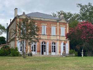 uma grande casa de tijolos num campo de relva em 1812 Route de Baziège à Labège em Labège