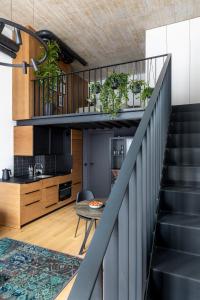 a staircase leading up to a kitchen and a living room at Stylish loft with terrace Paupys, Old town in Vilnius