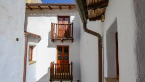 - un bâtiment avec 2 balcons et une porte rouge dans l'établissement Casa Clara, à Mamoiada