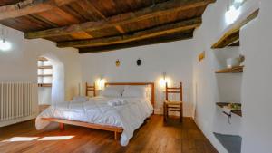 - une chambre avec un lit et un plafond en bois dans l'établissement Casa Clara, à Mamoiada